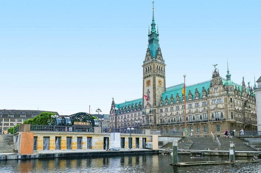 Un edificio histórico con una torre de reloj, un río y un puente. 1