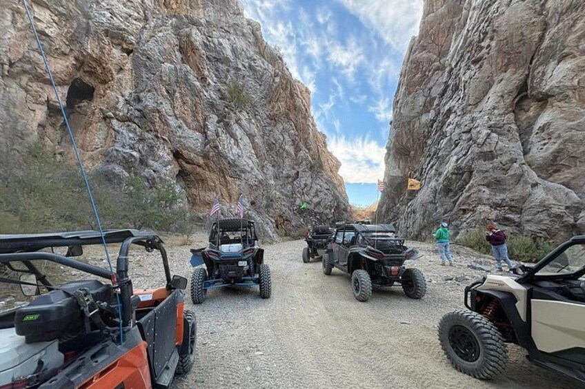 Off-road vehicles on a gravel path between rocky cliffs. 1