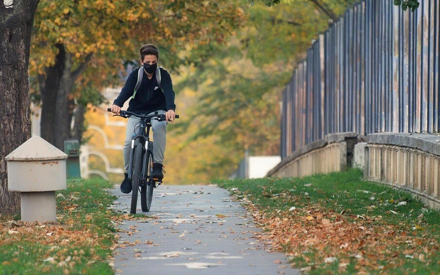 A person riding a bicycle on a leaf-covered path. 2