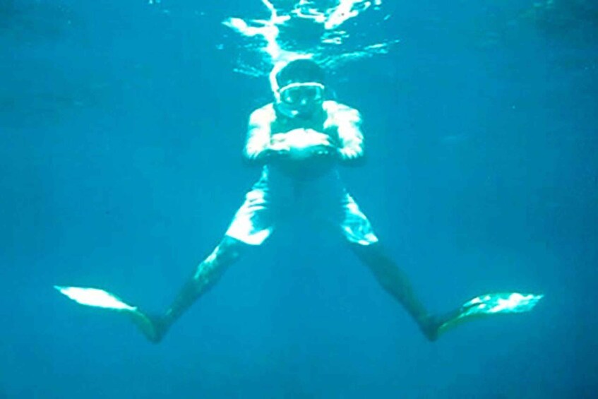 A person swimming underwater. 1