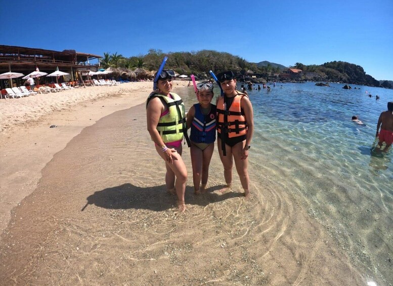 A beach with clear water, sun loungers, and people swimming. 2