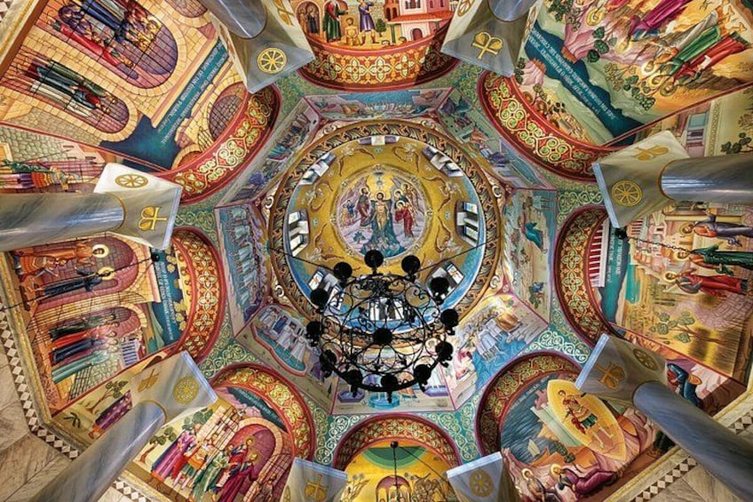 A detailed, colorful dome ceiling with intricate mosaics and a central chandelier. 2