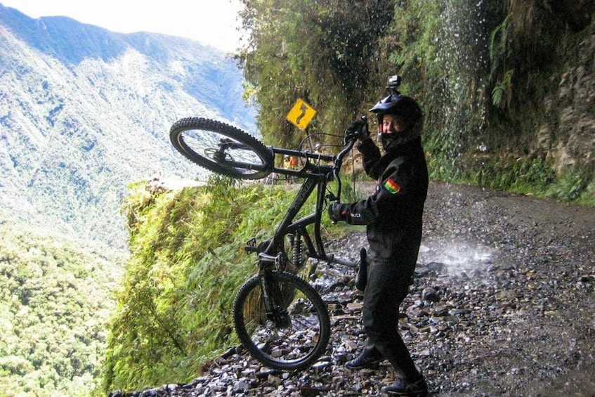 A mountain biker on a rocky path with a mountain in the background. 3
