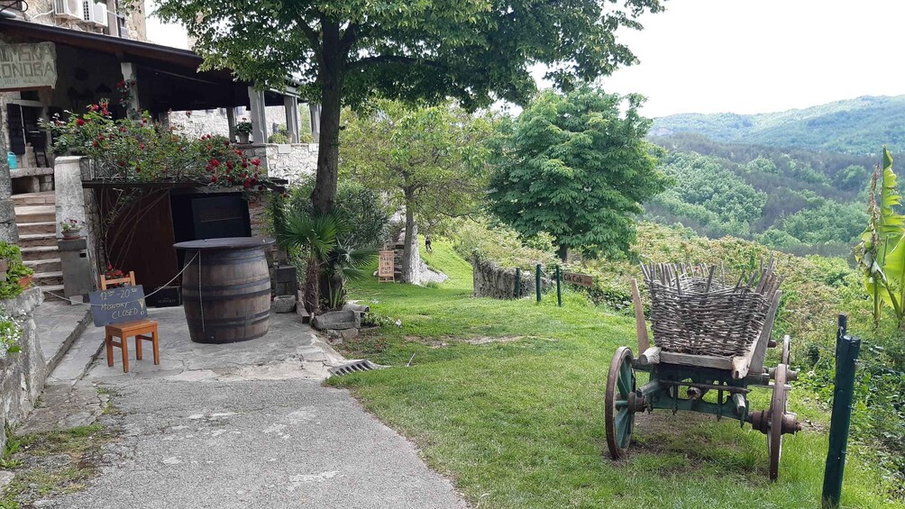 A rustic outdoor seating area with a wooden barrel, a chair, and a sign indicating 'Monday CLOSED'. 4