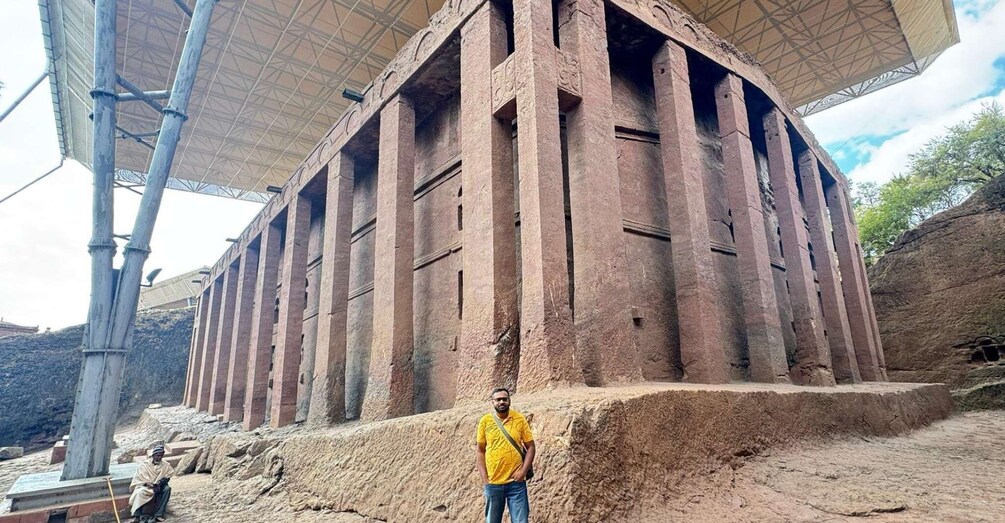 A large ancient stone structure with columns and a covered area. 4