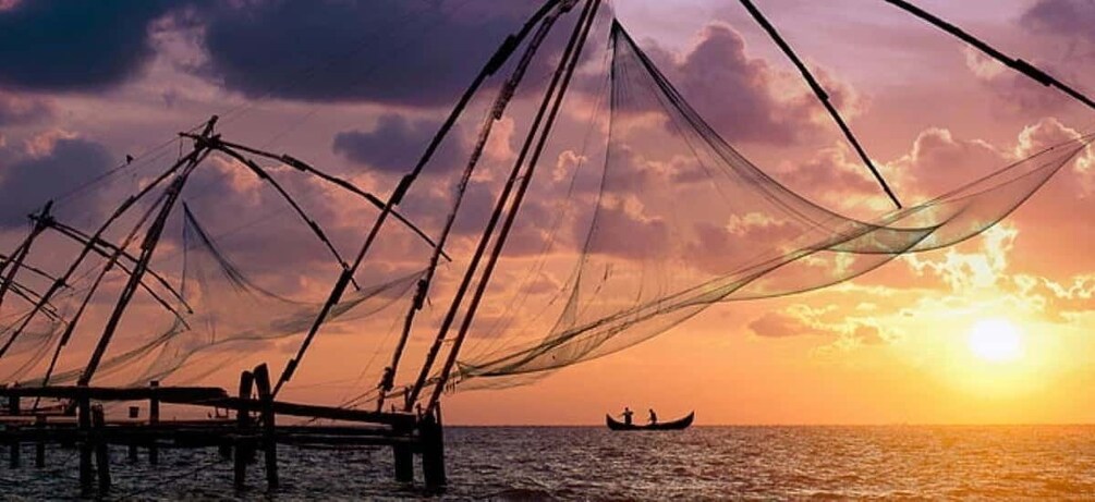 A fishing net structure at sunset with a boat in the distance. 5