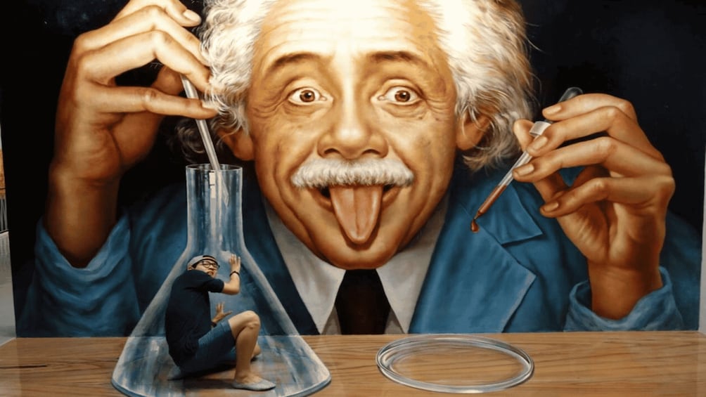 A person in a lab coat holding a test tube and a pipette. 1
