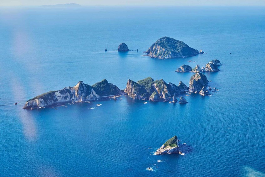 A coastal landscape with several rocky islands surrounded by deep blue water. 3