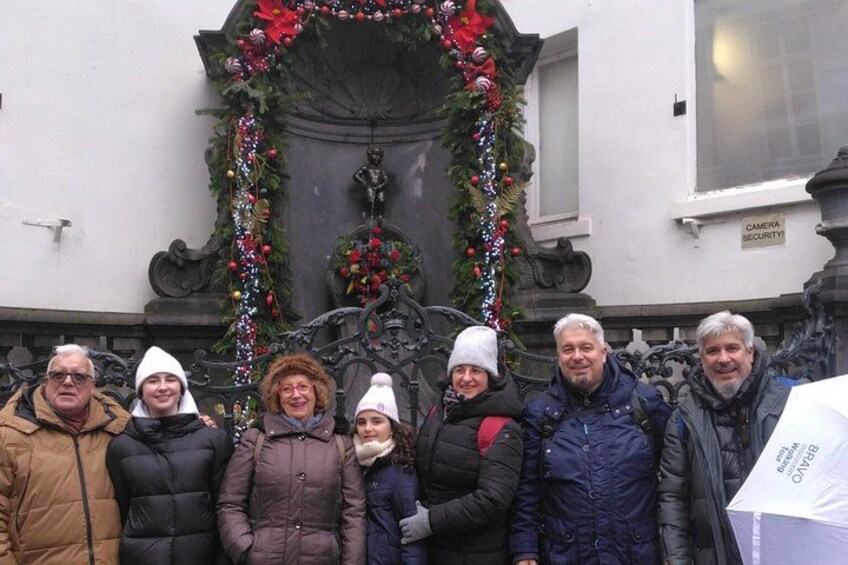 A group of people standing in front of a building with a decorative wreath and garland. 4