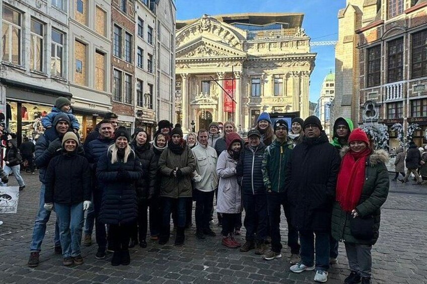 A group of people standing in a cobblestone street with historic buildings in the background. 3