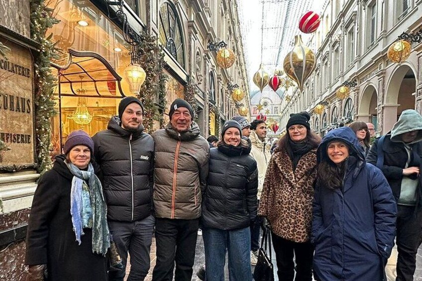 A group of people standing on a street with shops and festive decorations. 2