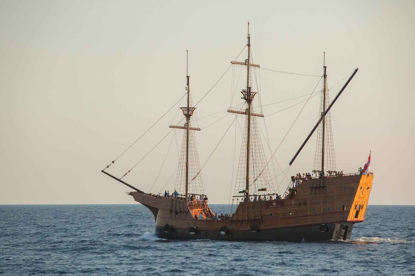 A wooden sailing ship with multiple masts and rigging on the ocean. 1