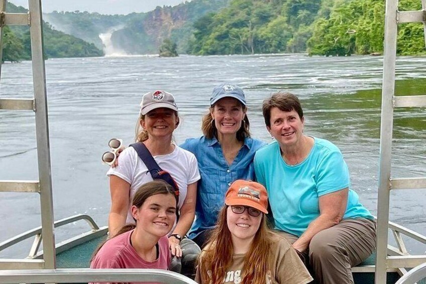 A group of people on a boat with a river and greenery in the background. 5