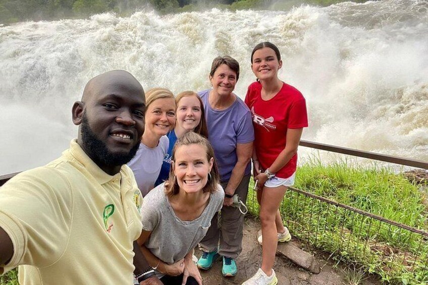 A group of people taking a selfie in front of a waterfall. 2