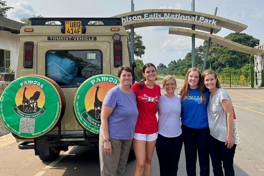 A group of people standing in front of a tourist vehicle with 'On Falls National Park' signage. 4