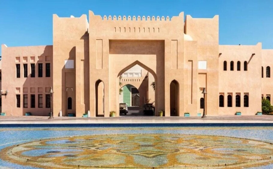 A large building with a central archway and a decorative pool in front. 5