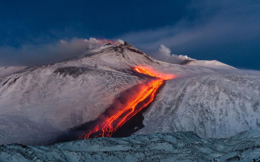 A snow-covered mountain with a flowing lava river. 3