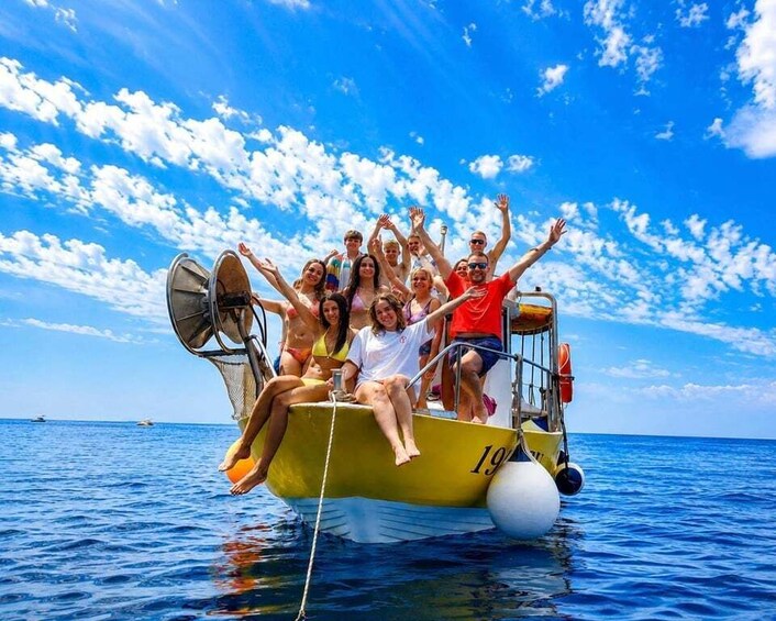 A group of people on a boat with the number 19 visible, enjoying a sunny day on the water. 2