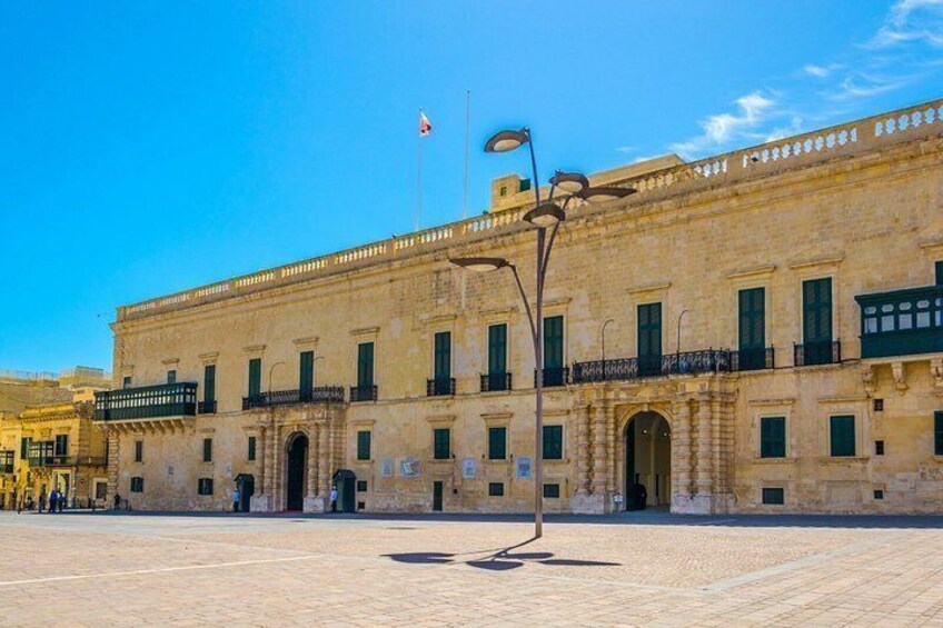 Un edificio histórico con ventanas de arco y un asta de banderas. 2