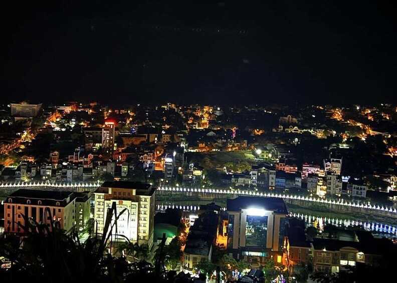 A cityscape at night with illuminated buildings and a bridge. 1