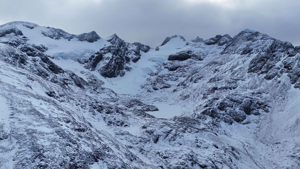 A snow-covered mountain range with rugged peaks and a valley. 2