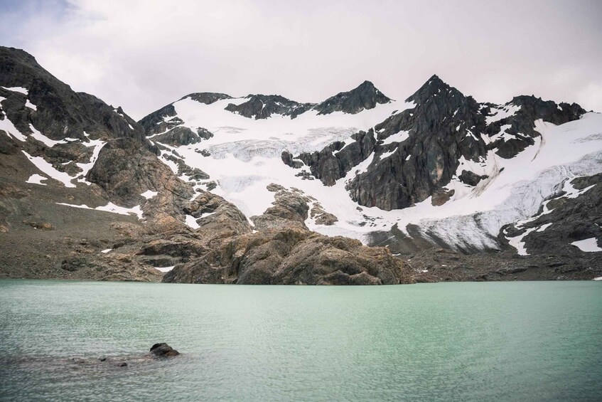 A mountain landscape with a clear turquoise lake and snow-capped peaks. 5