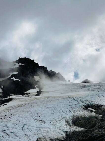 A glacier with ice formations and a rugged mountain in the background. 5