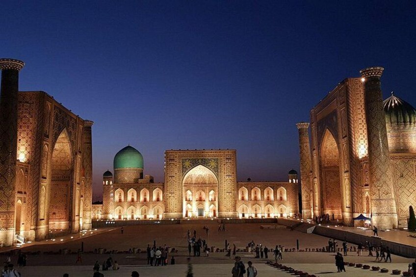 A large, illuminated mosque with domes and arches, surrounded by a spacious courtyard. 5