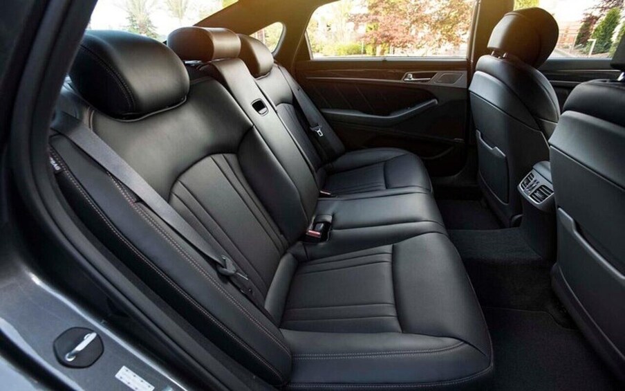 A car's interior with black leather seats and a center console. 4