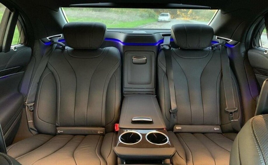 A car's interior with two seats, a center console, and blue ambient lighting. 5