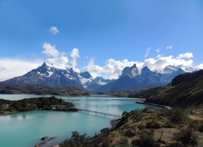 A lake surrounded by mountains with a bridge in the foreground. 1