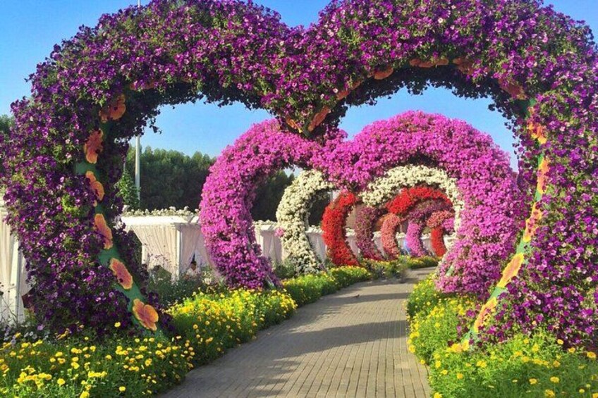 A pathway lined with heart-shaped floral arrangements and a variety of colorful flowers. 4