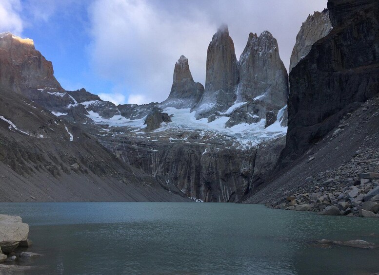A glacier lake surrounded by rugged mountains with snow patches. 1