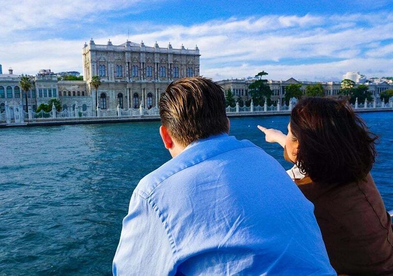 Un couple se trouve sur un bateau, d’où il a une vue sur un bâtiment historique situé au bord de l’eau. 2