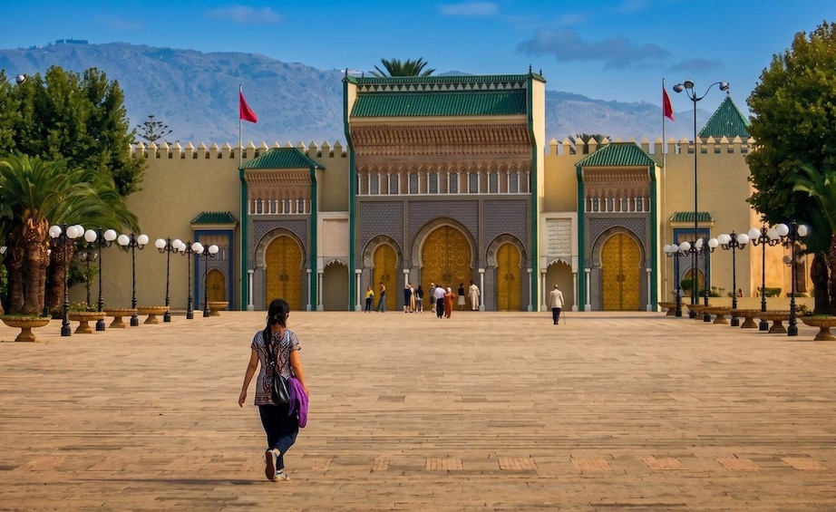 A large open courtyard with a prominent building featuring arches and a green roof. 4