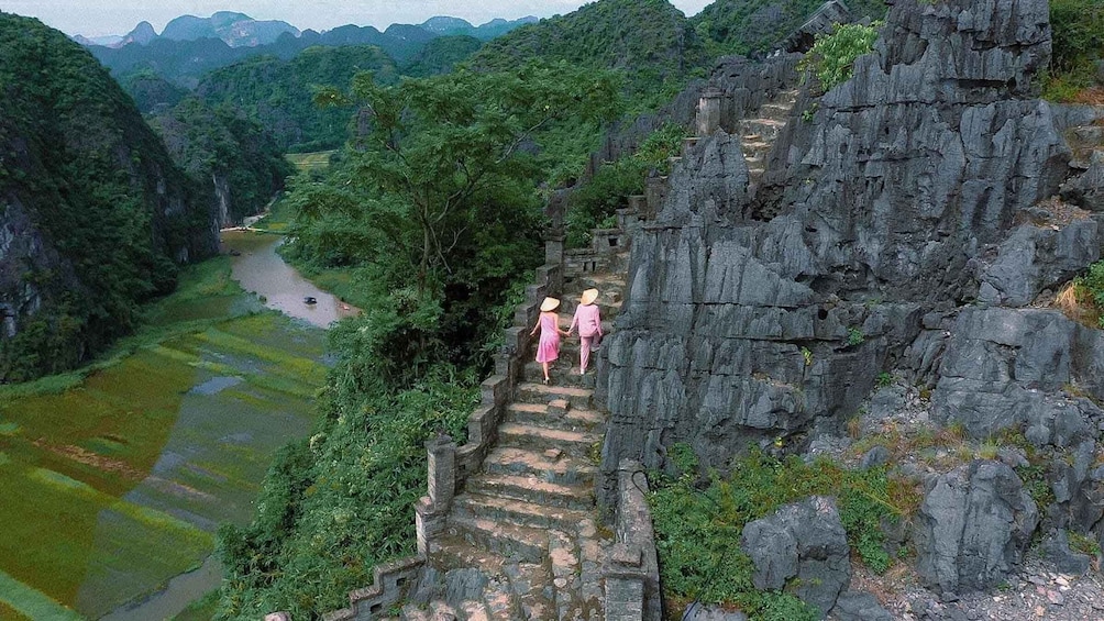 A river flowing through a valley with a stone staircase leading up a cliff. 2