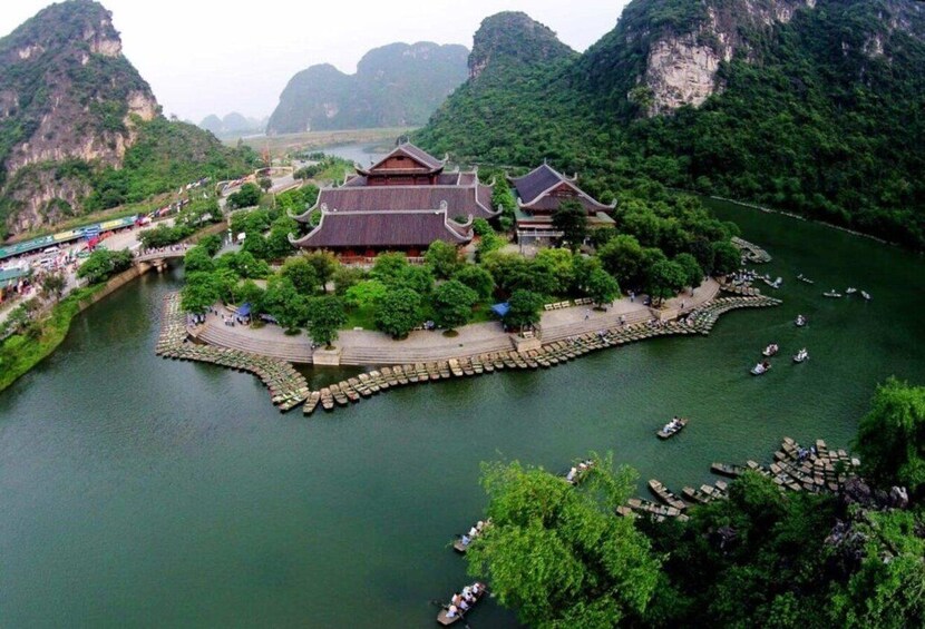 A traditional Chinese building surrounded by a river with boats. 5