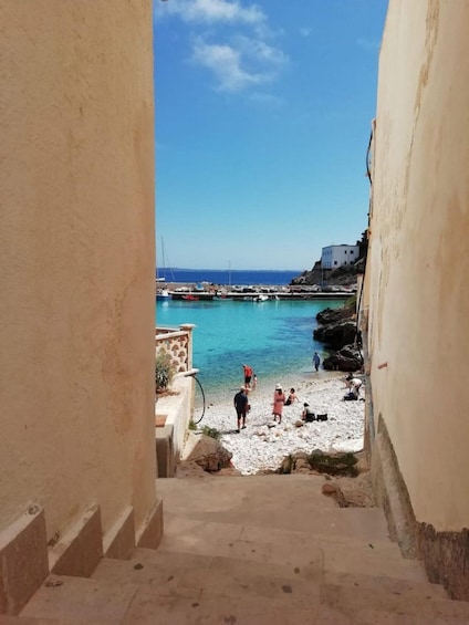 A coastal town with a beach, people, and boats. 5
