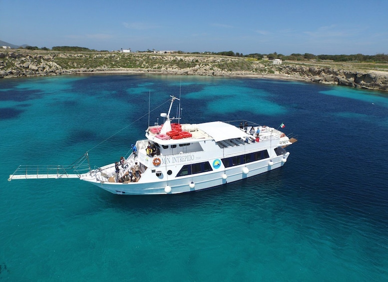 A white boat named MIN INTREPIDO 1726 on turquoise waters. 1
