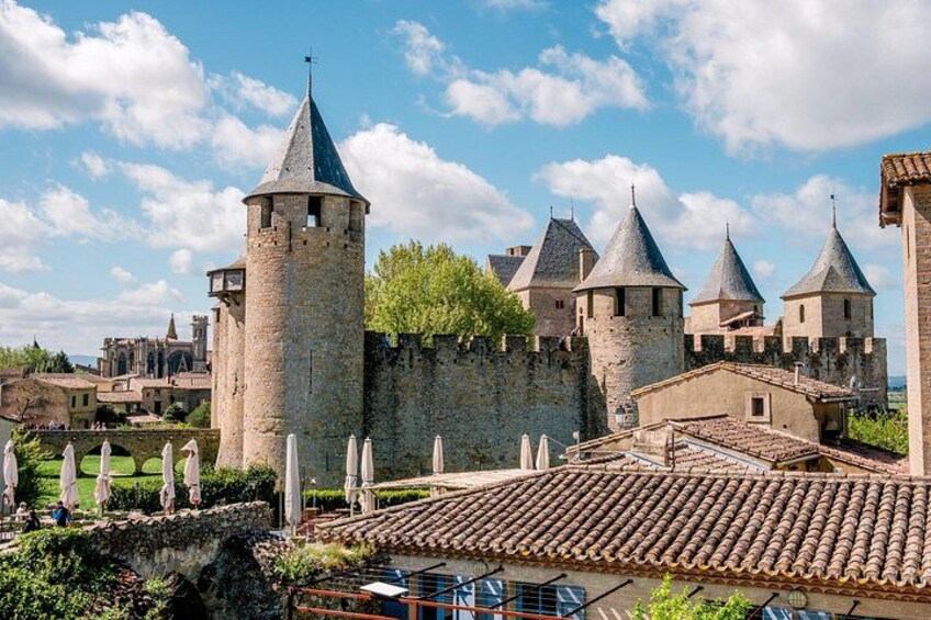 Un castillo medieval con múltiples torres, una muralla de piedra y un edificio con techo de tejas. 2
