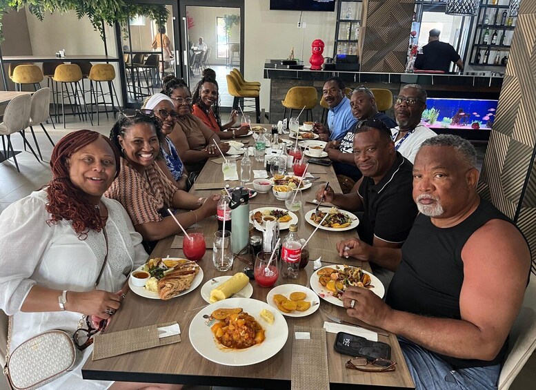 A group of people dining at a restaurant with various dishes and drinks on the table. 1
