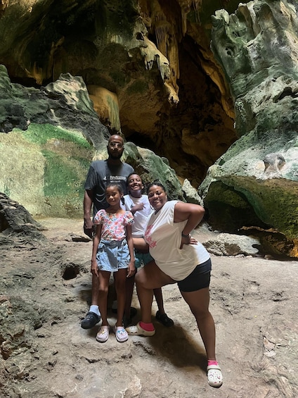 A group of people standing in a cave with stalactites and stalagmites. 3