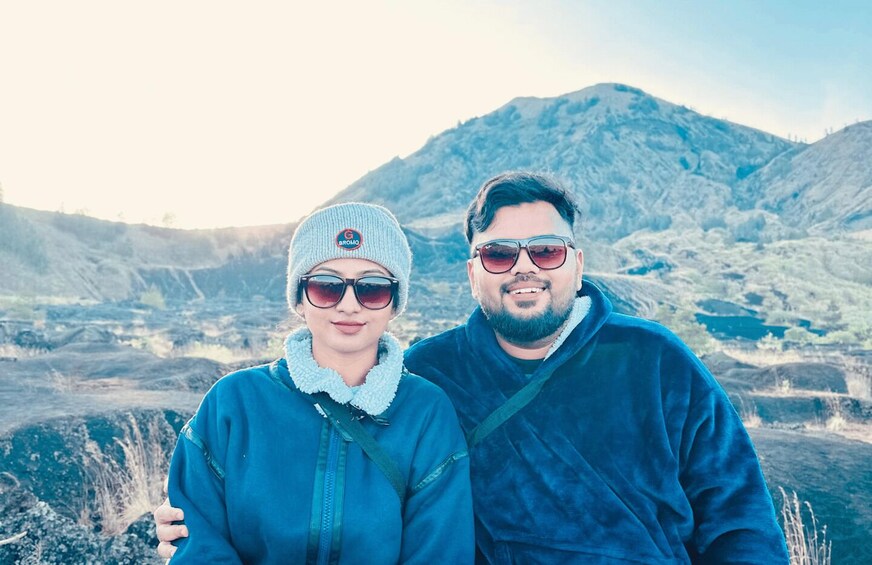 Two people standing in a mountainous area with a clear sky. 3