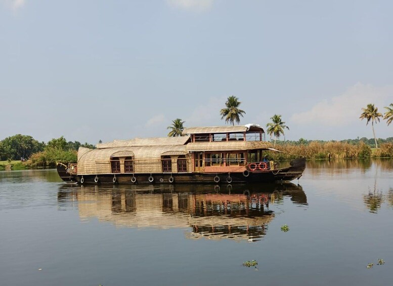Une péniche traditionnelle sur une rivière paisible, avec des palmiers en arrière-plan. 1