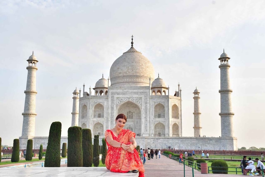The Taj Mahal with a person sitting in front of it. 1