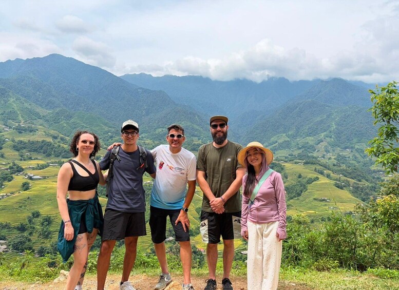 A group of people standing on a hill with a mountainous landscape in the background. 4