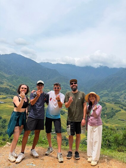 A group of people standing on a hill with a mountainous landscape in the background. 3