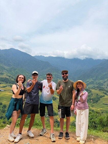 A group of people standing on a hill with a mountainous landscape in the background. 5