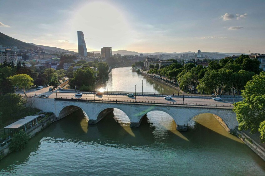 A river with a bridge, a tall building, and a cityscape in the background. 3