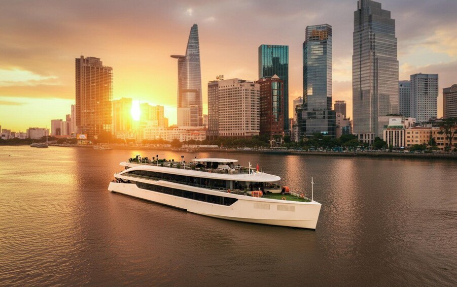 A river cruise ship in a city with a skyline of modern skyscrapers during sunset. 1